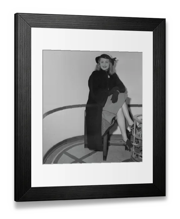 Framed Print : Nancy Guild Wearing Hat and Coat and Sitting on a Stool Framed Print : Nancy Guild Wearing Hat and Coat and Sitting on a Stool