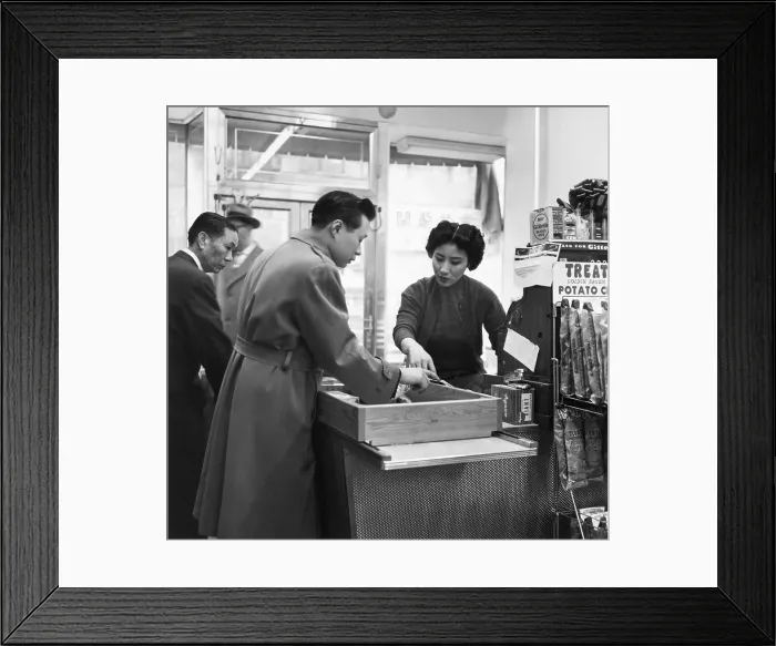 Framed Print : Clerk at Counter Checks Customer and Goods Framed Print : Clerk at Counter Checks Customer and Goods