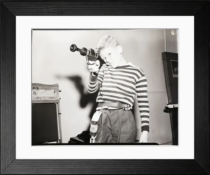 Framed Print : Child Takes Aim with Futuristic Toy Gun Framed Print : Child Takes Aim with Futuristic Toy Gun