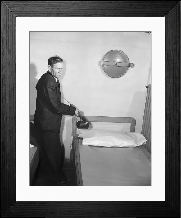 Framed Print : Man Spraying Hotel Bed with Ddt