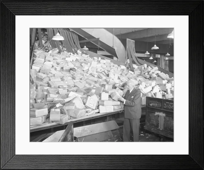 Framed Print : Postmaster Looking at Packages Framed Print : Postmaster Looking at Packages