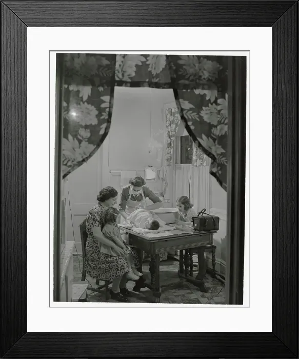 Framed Print : Family Watching Visiting Nurse Changing Diaper on Baby Framed Print : Family Watching Visiting Nurse Changing Diaper on Baby