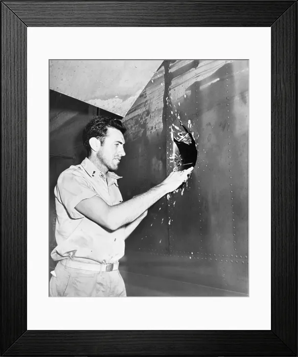 Framed Print : Lt. Lou Zamperini examining hole in airplane