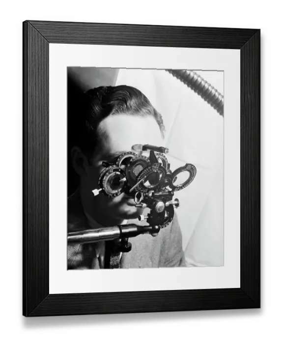Framed Print : Man Looking Into Phoropter Framed Print : Man Looking Into Phoropter
