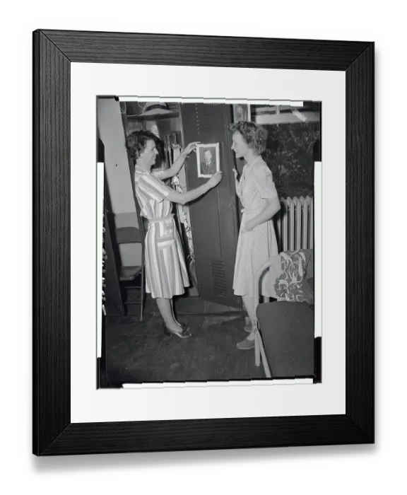 Framed Print : Military Women Hanging Portraits on Wall Framed Print : Military Women Hanging Portraits on Wall