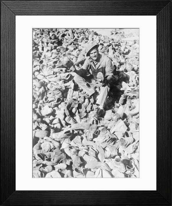 Framed Print : Man Sitting Amidst Pile of Military Boots Framed Print : Man Sitting Amidst Pile of Military Boots
