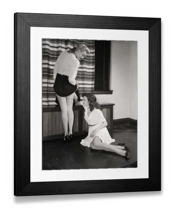 Framed Print : Woman Draws Hosiery Line on Model's Leg Framed Print : Woman Draws Hosiery Line on Model's Leg