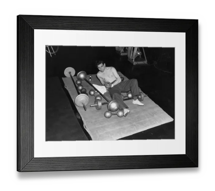 Framed Print : Joseph Shuster Lying on Mat with Barbells