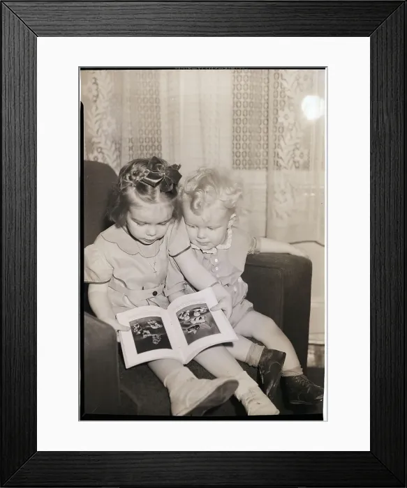 Framed Print : Young Sister and Brother Looking at Book