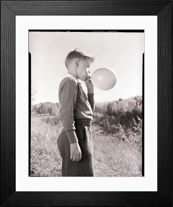 Framed Print : Boy Blowing a Balloon Framed Print : Boy Blowing a Balloon