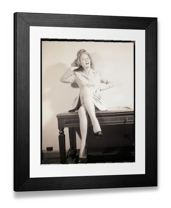 Framed Print : Woman Seated on Desk with Legs Crossed Framed Print : Woman Seated on Desk with Legs Crossed