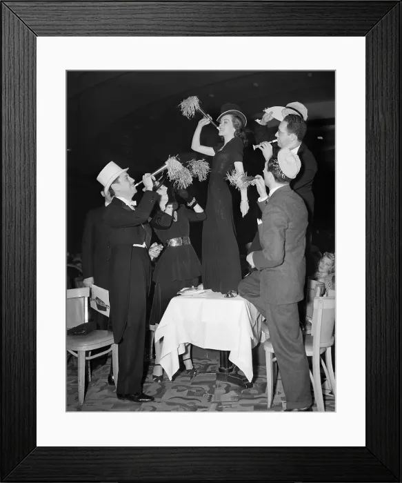 Framed Print : Woman on Table Blowing Noisemaker Framed Print : Woman on Table Blowing Noisemaker