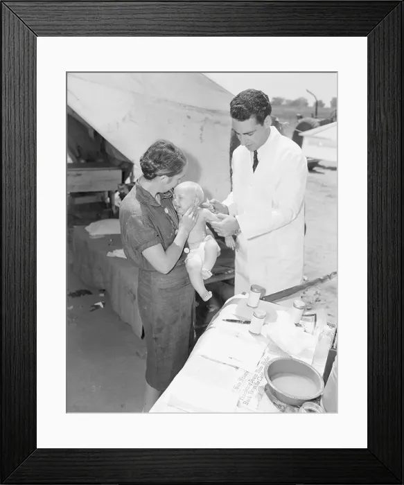 Framed Print : Nurse Holding Migrant Baby for Doctor Framed Print : Nurse Holding Migrant Baby for Doctor