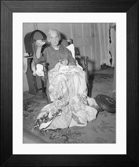 Framed Print : Elderly Woman Sews Blanket In Home Framed Print : Elderly Woman Sews Blanket In Home