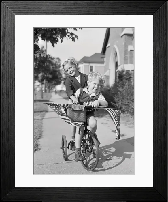 Framed Print : Boy and girl (8-9 years) riding bicycle, smiling. Phipps Garden apartment, Sunnyside, New York State, USA. September 08, 1938 Framed Print : Boy and girl (8-9 years) riding bicycle, smiling. Phipps Garden apartment, Sunnyside, New York State, USA. September 08, 1938