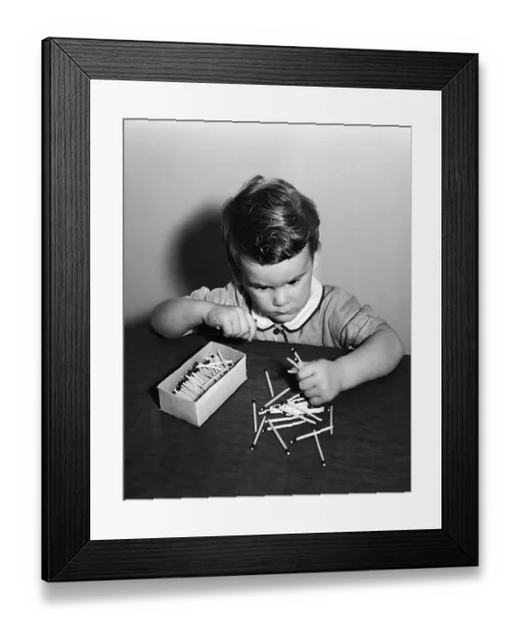 Framed Print : Vintage photograph showing boy (4-5) playing with matches Framed Print : Vintage photograph showing boy (4-5) playing with matches
