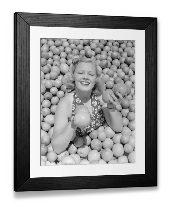 Framed Print : Woman Buried in Pile of Oranges Framed Print : Woman Buried in Pile of Oranges
