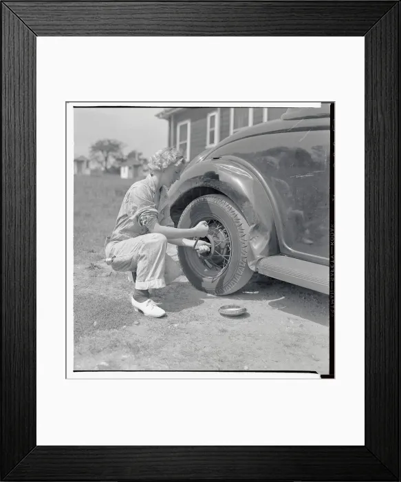 Framed Print : Woman Changing Tire at Gas Station Framed Print : Woman Changing Tire at Gas Station