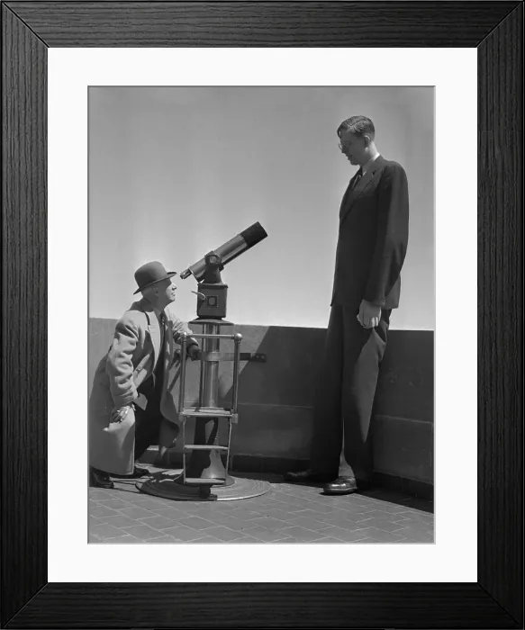 Framed Print : Man Looking at Wadlow Through Telescope Framed Print : Man Looking at Wadlow Through Telescope