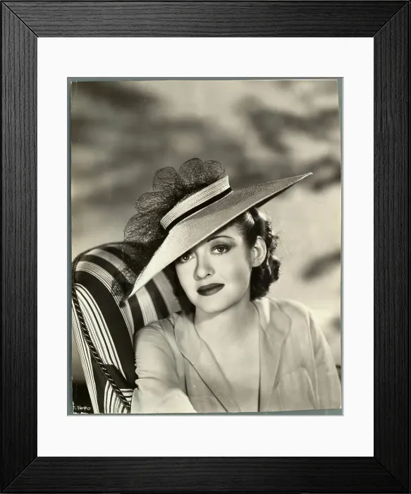 Framed Print : Actress Bette Davis Sitting in Chair and Wearing Hat Framed Print : Actress Bette Davis Sitting in Chair and Wearing Hat