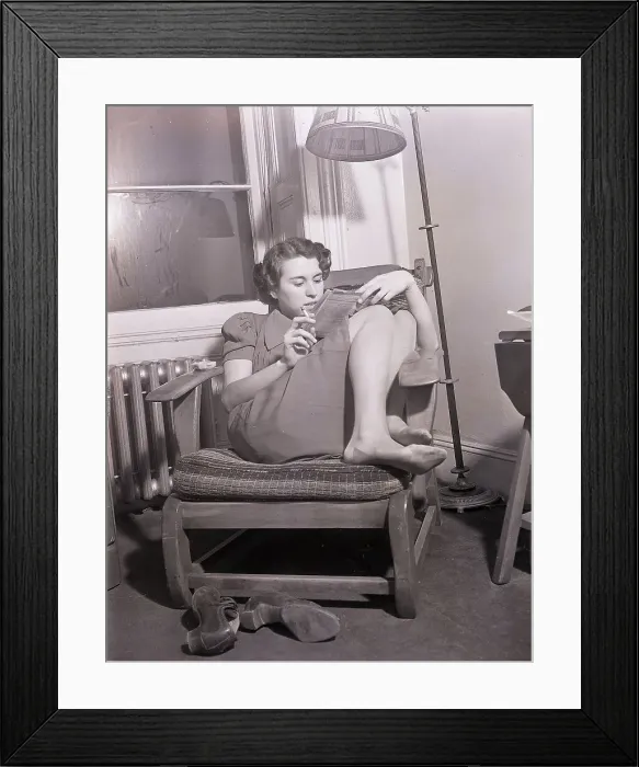 Framed Print : Store Clerk Curled Up Reading in Chair Framed Print : Store Clerk Curled Up Reading in Chair