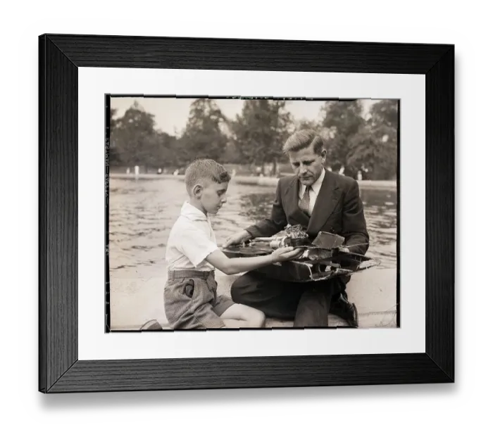 Framed Print : Boy Showing Wrecked Model Boat To Man Framed Print : Boy Showing Wrecked Model Boat To Man