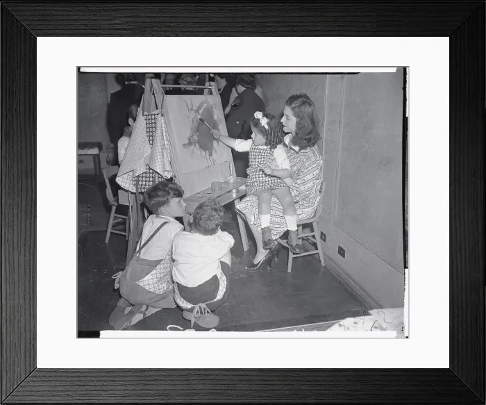 Framed Print : Teacher Holding Child Making Painting Framed Print : Teacher Holding Child Making Painting
