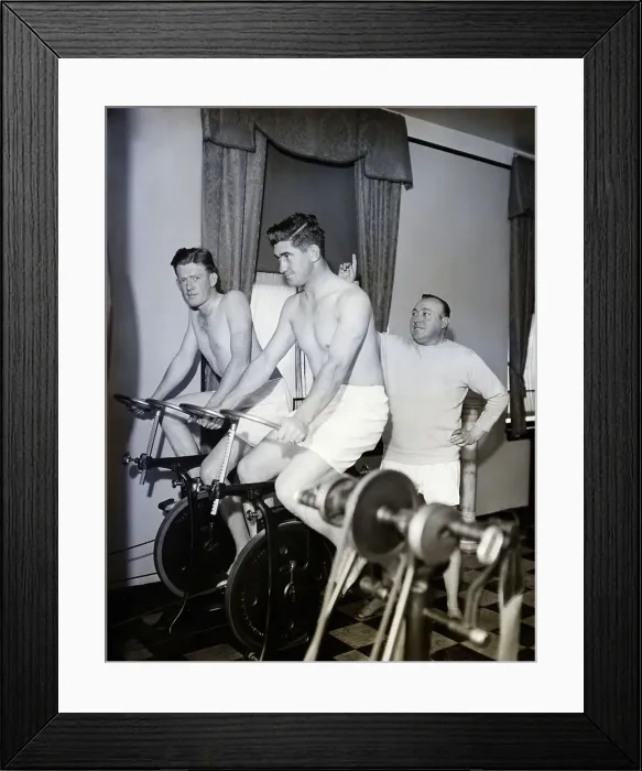 Framed Print : Coach And Men Riding Stationary Bikes