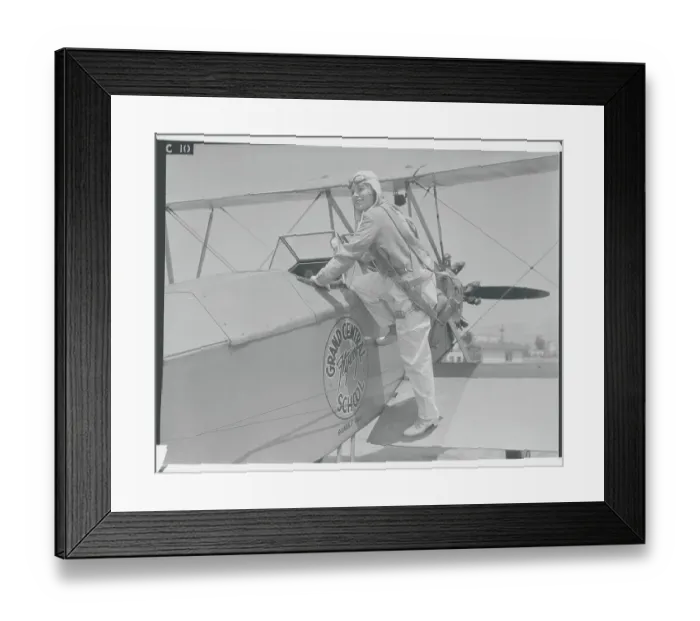 Framed Print : Young Aviatrix Climbing into Airplane Framed Print : Young Aviatrix Climbing into Airplane