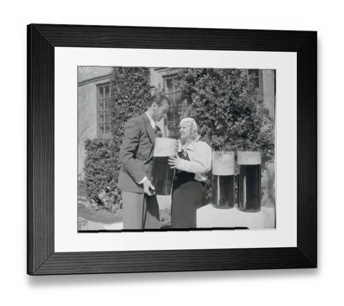 Framed Print : Mae West and Gary Cooper with Large Containers of Beer