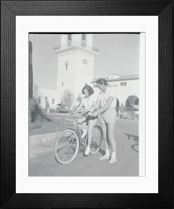 Framed Print : Johnny Weismuller Helping Lupe Velez on Bicycle Framed Print : Johnny Weismuller Helping Lupe Velez on Bicycle