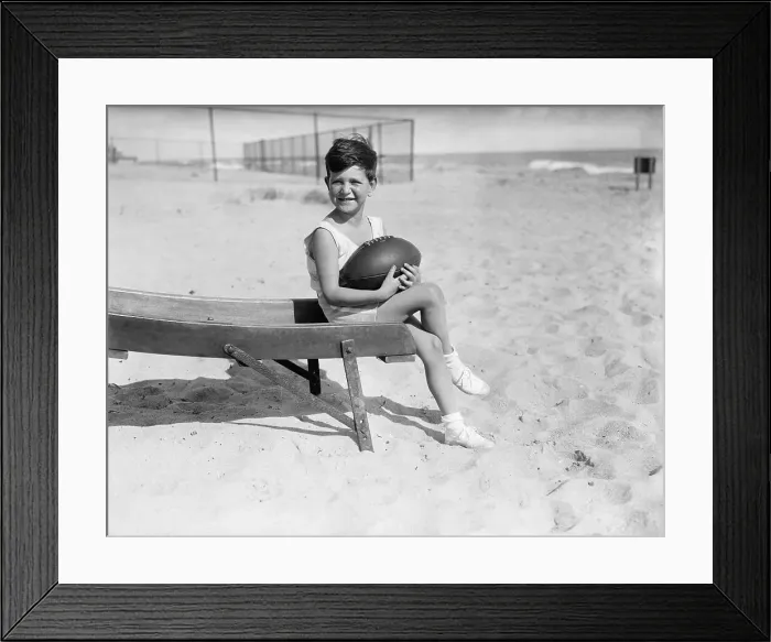 Framed Print : Boy (6-7) with ball sitting on beach
