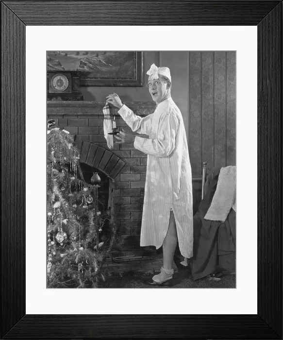 Framed Print : Man Hanging Stocking By Fireplace Framed Print : Man Hanging Stocking By Fireplace