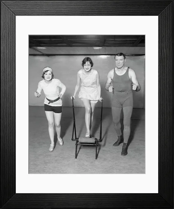 Framed Print : Man, Woman Run Alongside Woman On Machine Framed Print : Man, Woman Run Alongside Woman On Machine
