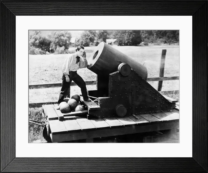 Framed Print : Buster Keaton Standing in Front of Cannon Framed Print : Buster Keaton Standing in Front of Cannon