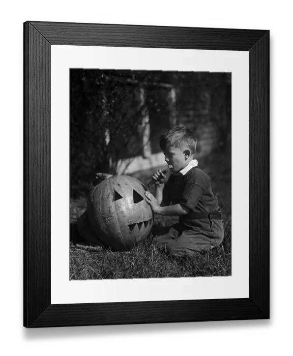 Framed Print : Vintage photograph showing, Boy (8-9) Carving Jack-O-lantern Framed Print : Vintage photograph showing, Boy (8-9) Carving Jack-O-lantern
