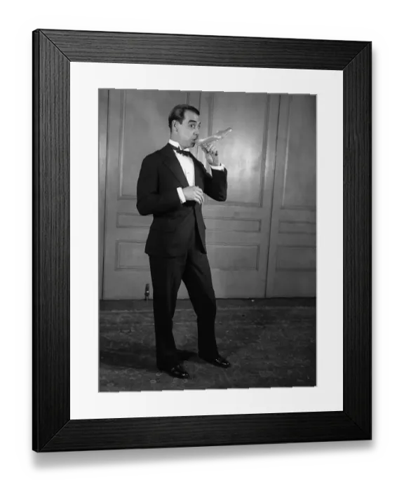 Framed Print : Studio shot of elegant man drinking from high heel shoe Framed Print : Studio shot of elegant man drinking from high heel shoe