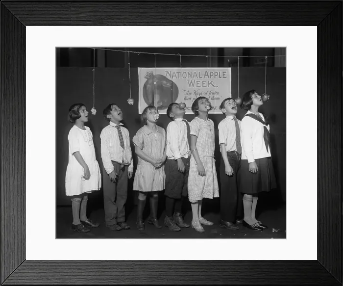 Framed Print : Children Attempting To Bite Apples
