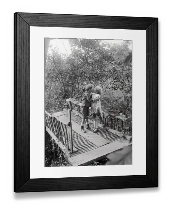 Framed Print : Girl and boy (6-7 years) kissing on bridge. August 05, 1925 Framed Print : Girl and boy (6-7 years) kissing on bridge. August 05, 1925