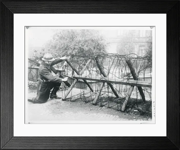Framed Print : Soldier Stooping to Work on Fence Framed Print : Soldier Stooping to Work on Fence