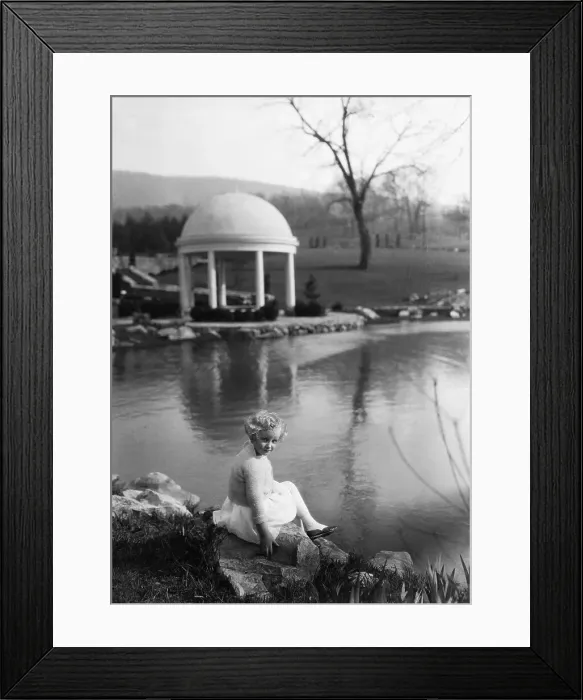 Framed Print : Young girl (6-7 years) relaxing on rock in park. Hot Springs, Virginia, USA. April 08, 1922