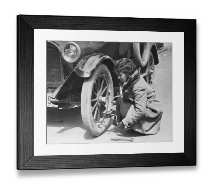 Framed Print : Young Woman Fixing Flat On Old Car Framed Print : Young Woman Fixing Flat On Old Car
