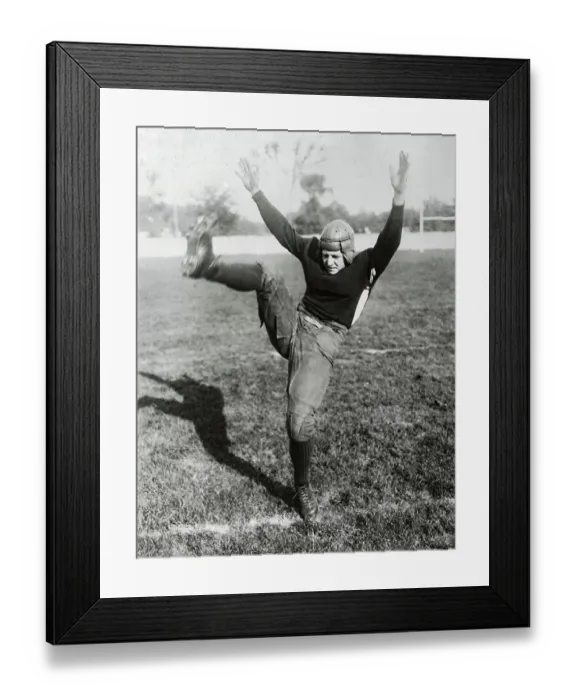 Framed Print : Red Grange Kicking Football