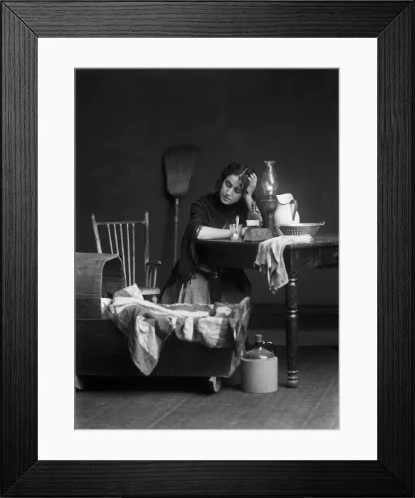 Framed Print : Woman sitting next to crib Framed Print : Woman sitting next to crib