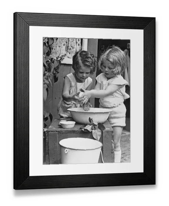 Framed Print : Girls (6-7) washing hands in wash bowl Framed Print : Girls (6-7) washing hands in wash bowl