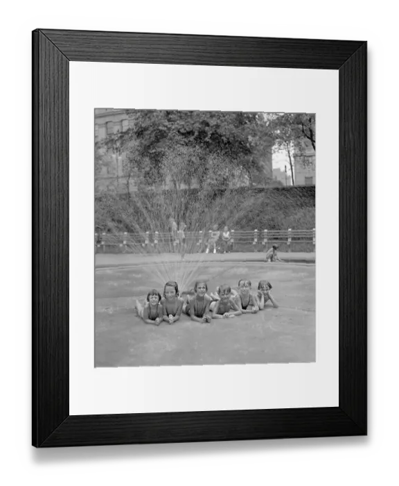 Framed Print : Group of girls (6-7) and (8-9) boys taking refuge from heat under sprinkler Framed Print : Group of girls (6-7) and (8-9) boys taking refuge from heat under sprinkler