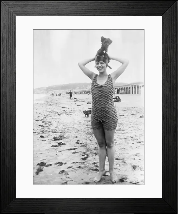 Framed Print : Young woman standing in sandy beach with dog on top of head Framed Print : Young woman standing in sandy beach with dog on top of head