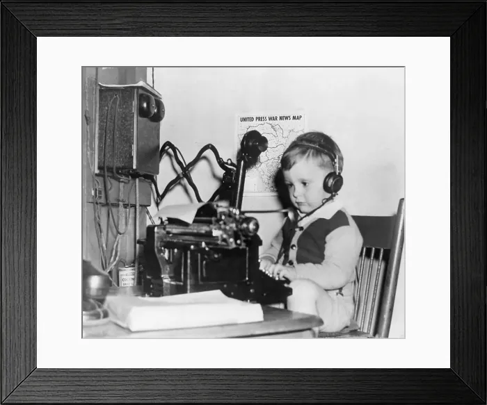 Framed Print : Vintage photograph showing young boy (6-7) p-laying receptionist