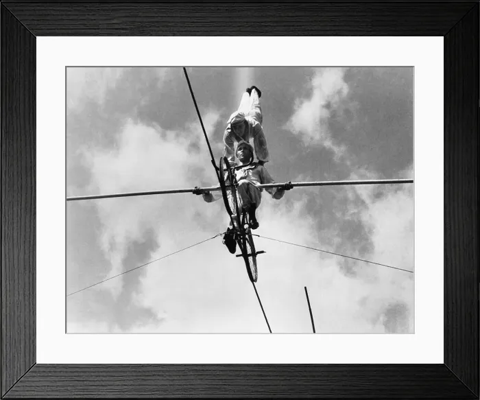 Framed Print : Acrobats on tightrope, low angle view Framed Print : Acrobats on tightrope, low angle view