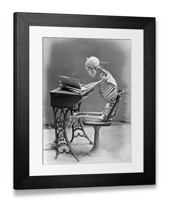 Framed Print : Skeleton Reading at Desk Framed Print : Skeleton Reading at Desk